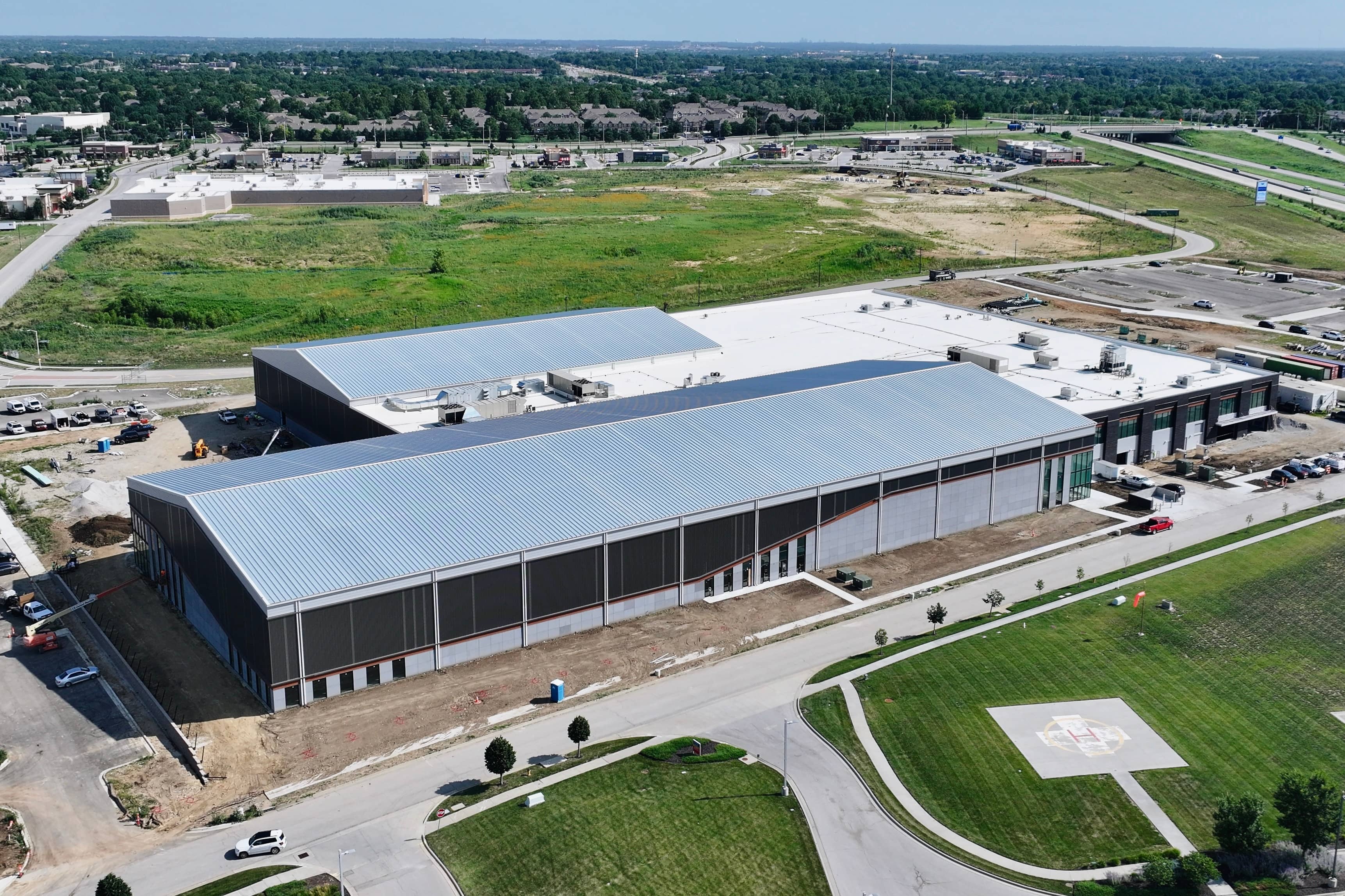 Aerial drone view of a JR&CO commercial jobsite with silver metal roofs